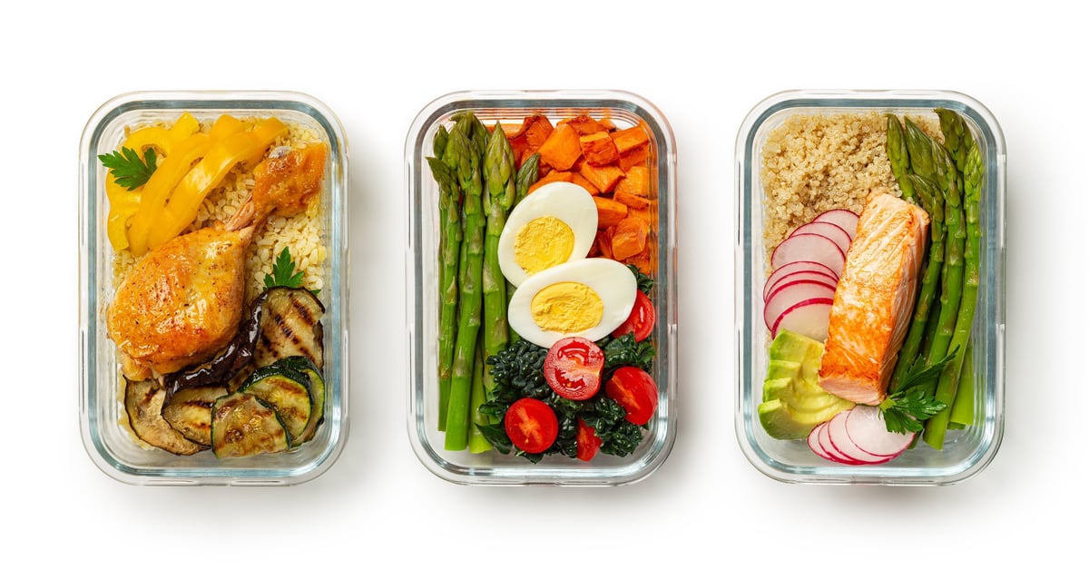 Healthy meal prep containers with salmon, quinoa, vegetables and fresh food